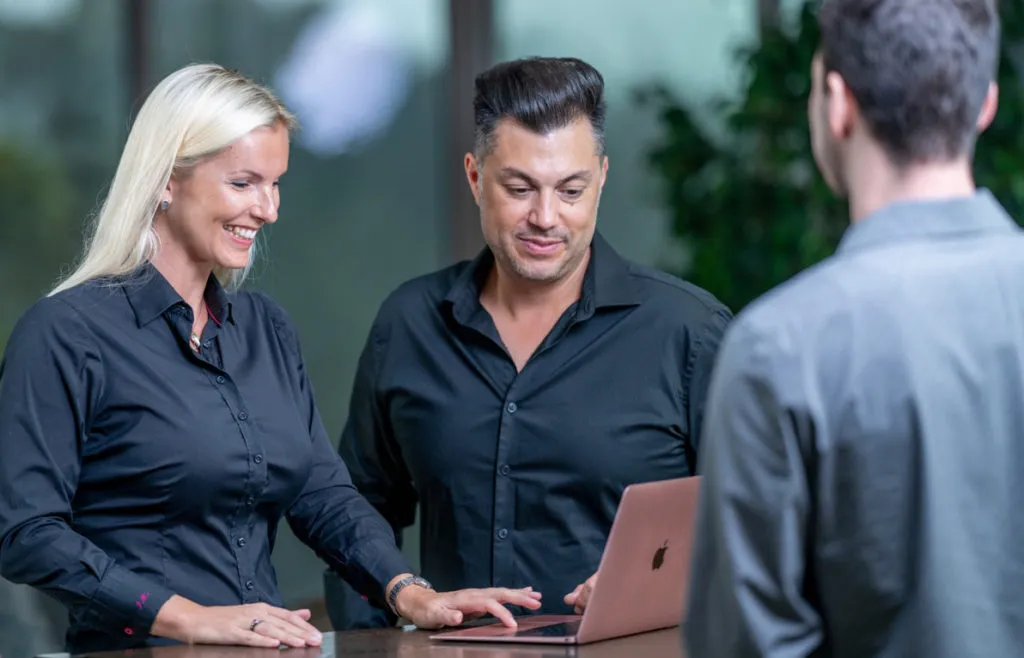 Jitka Putra in a meeting with two people, working at a laptop