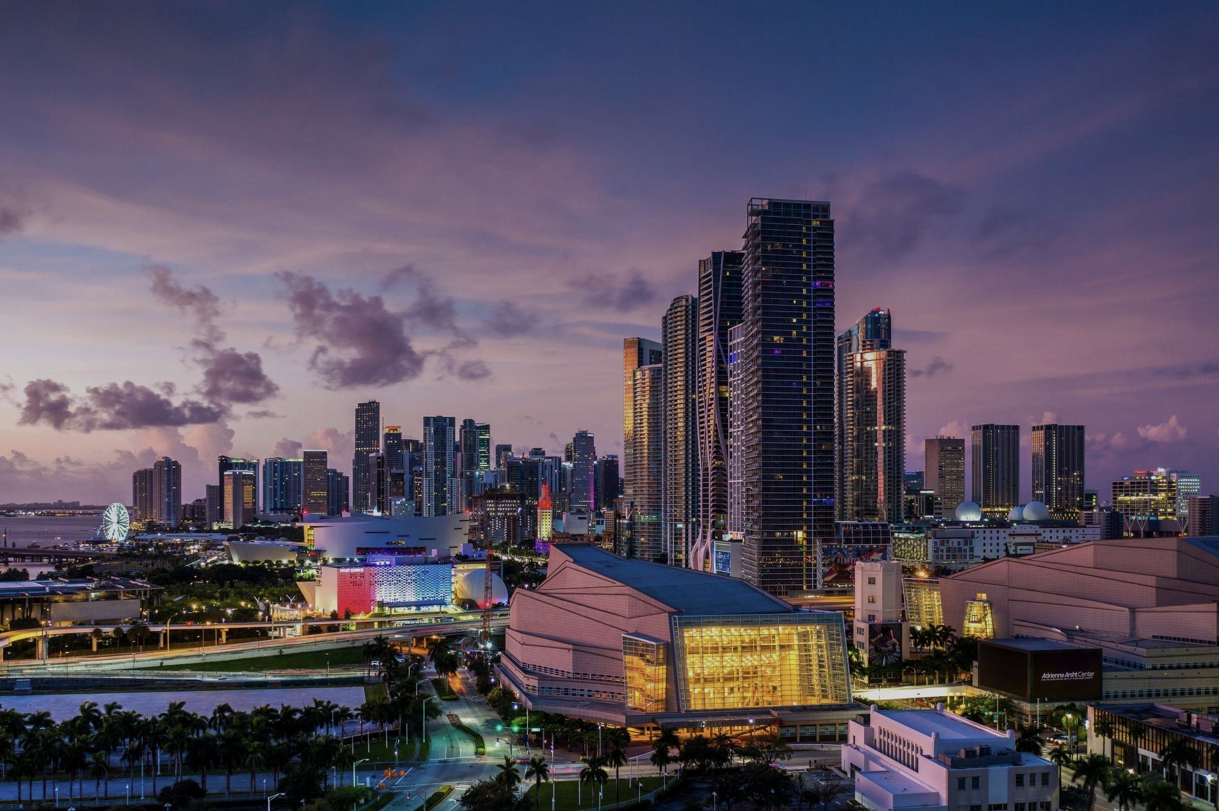 Downtown Miami at dusk, with the Adrienne Arsht Center lit below the towers